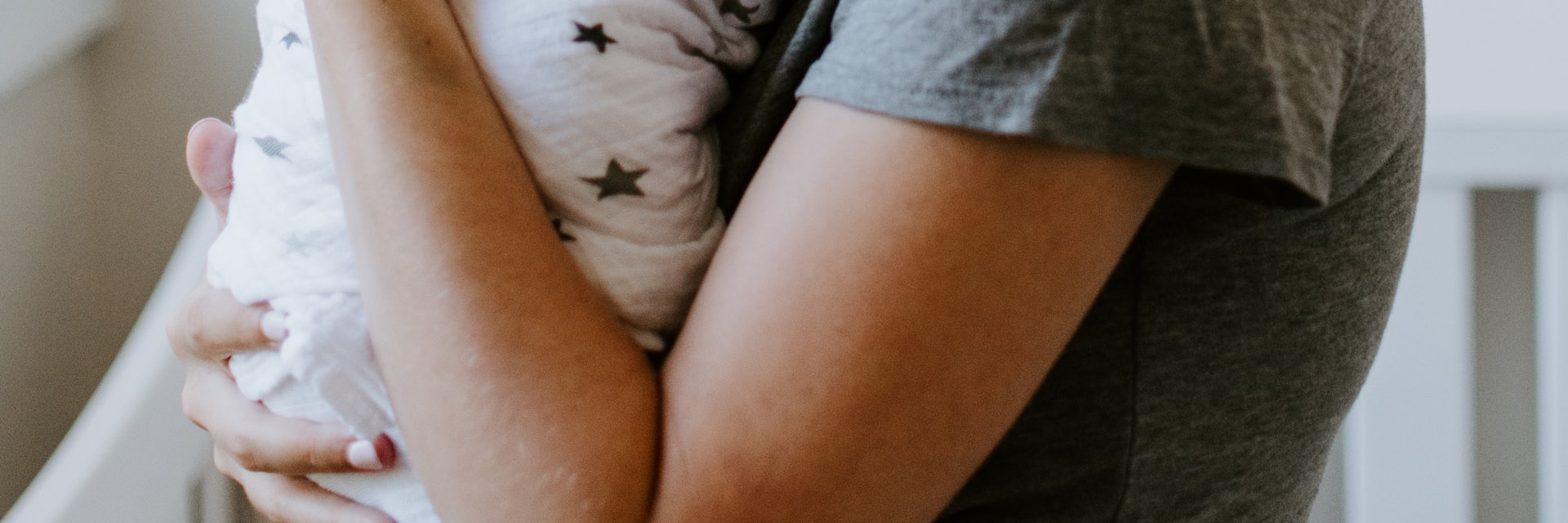 Neugeborenes geborgen im Arm – Kinderwunsch erfüllt