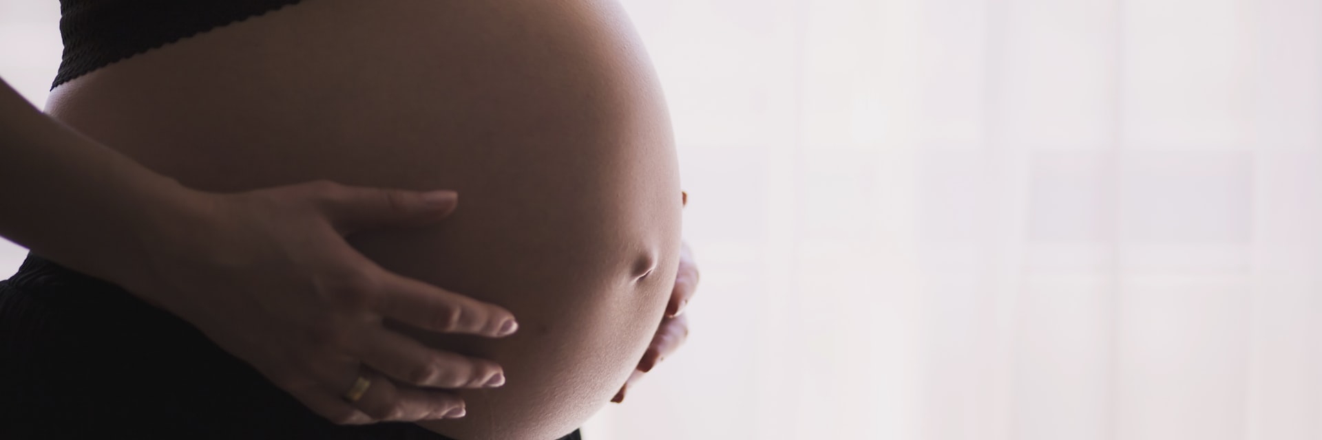 Schwangere Frau hält ihren Babybauch